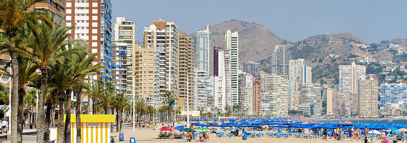 People by swimming pool against buildings in city