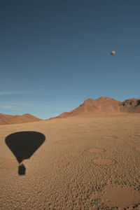 Hot air balloon in desert against sky