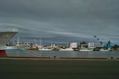 Boats moored at harbor against sky