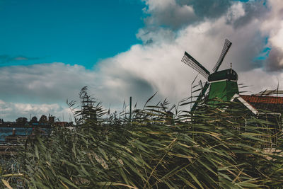 Traditional windmill on field against sky