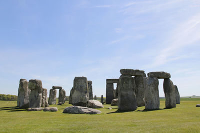 View of stonehenge with green meadow and blue sky on a sunny day in spring, united kingdom