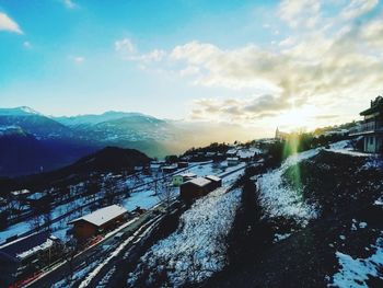 High angle view of buildings and mountains against sky during sunset