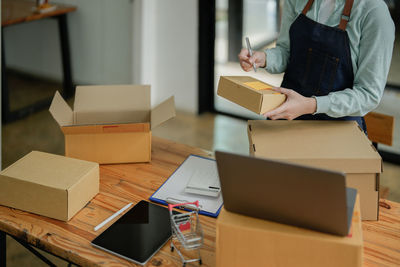 Midsection of woman holding box