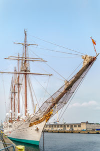 Sailboats moored in sea against sky