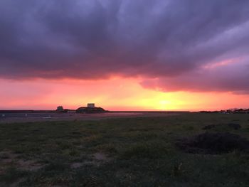 Scenic view of sea against dramatic sky during sunset