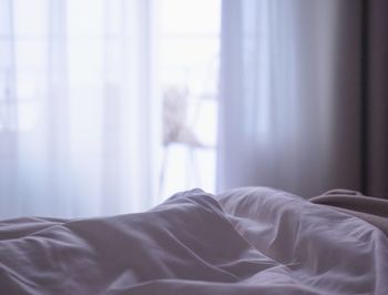 Midsection of man relaxing on bed at home