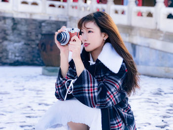 Young woman photographing with camera