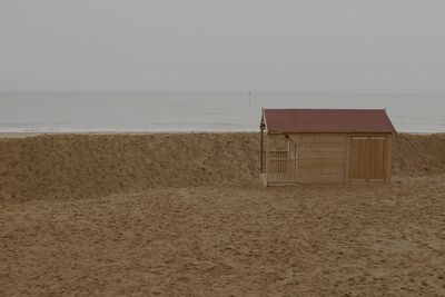 Lifeguard hut on beach against sky