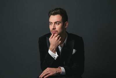Portrait of young man against black background