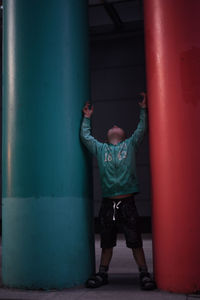 Rear view of boy standing in color columps