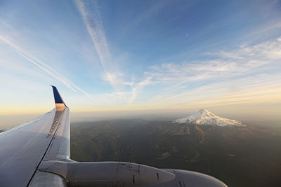 Airplane flying over landscape against sky