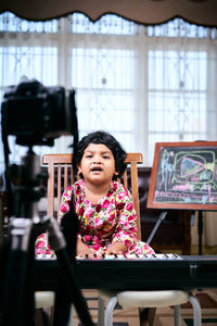 Portrait of a smiling girl sitting on table