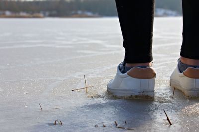 Low section of woman on frozen lake