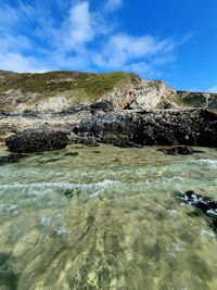 Rocks in sea against sky