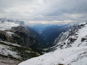 Scenic view of snowcapped tre cime di lavaredo against cloudy sky