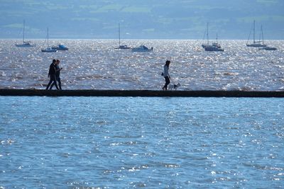 Men standing on sea against sky