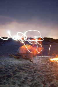 Digital composite image of light trails on beach