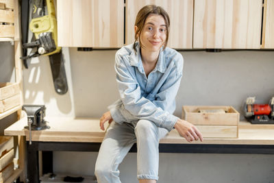 Portrait of a smiling young woman sitting at home