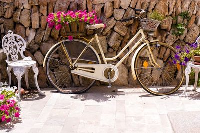 Bicycle parked by stone wall