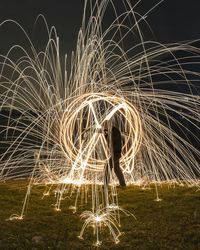 Side view of man spinning wire wool on field