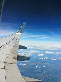 Cropped image of airplane flying over clouds