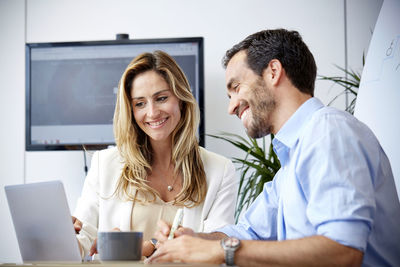 Smiling colleagues discussing in office