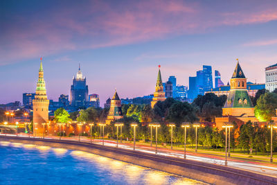 Illuminated buildings against sky at dusk