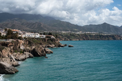 Scenic view of sea and mountains against sky