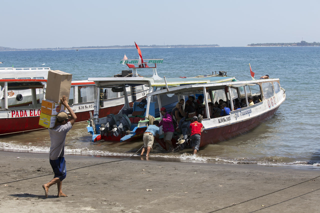 PEOPLE ENJOYING ON BEACH AGAINST SKY