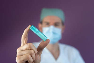 Close-up of human hand holding blue finger