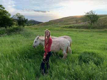 Full length of a teenage girl with two wild burros, along wildlife loop drive in custer state park