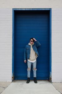 Full length of young woman standing against wall