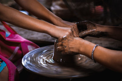 Cropped hands of girls making pottery in workshop