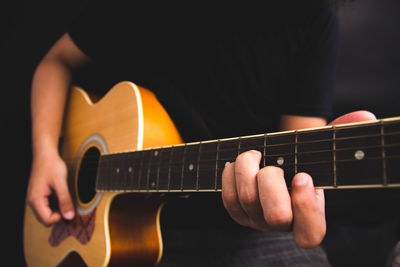 Midsection of man playing guitar