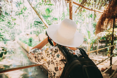 Rear view of woman standing against trees