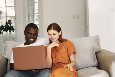 Young couple sitting on sofa at home