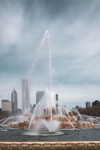 Fountain in city against sky