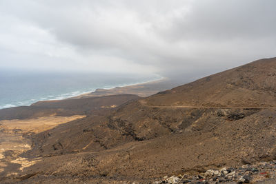 Scenic view of sea and mountains against sky