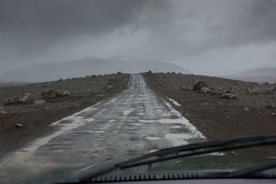 Mountain road against overcast sky