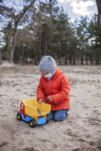 Boy playing with toy car on land