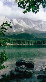 Scenic view of lake by mountains against sky