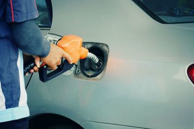 Midsection of man refueling car 