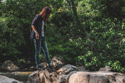 Man standing on rock in forest