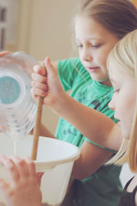 Cute friends preparing food in kitchen