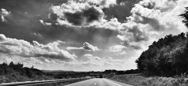 Road passing through landscape against sky