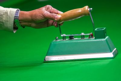 Cropped hand of man holding equipment on pool table