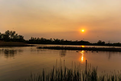 Scenic view of lake against sky during sunset