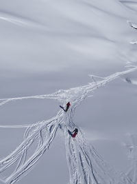 High angle view of people skiing on snow covered field