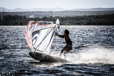 Full length of man skateboarding on sea against sky