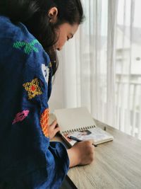 High angle view of woman sitting on table at home